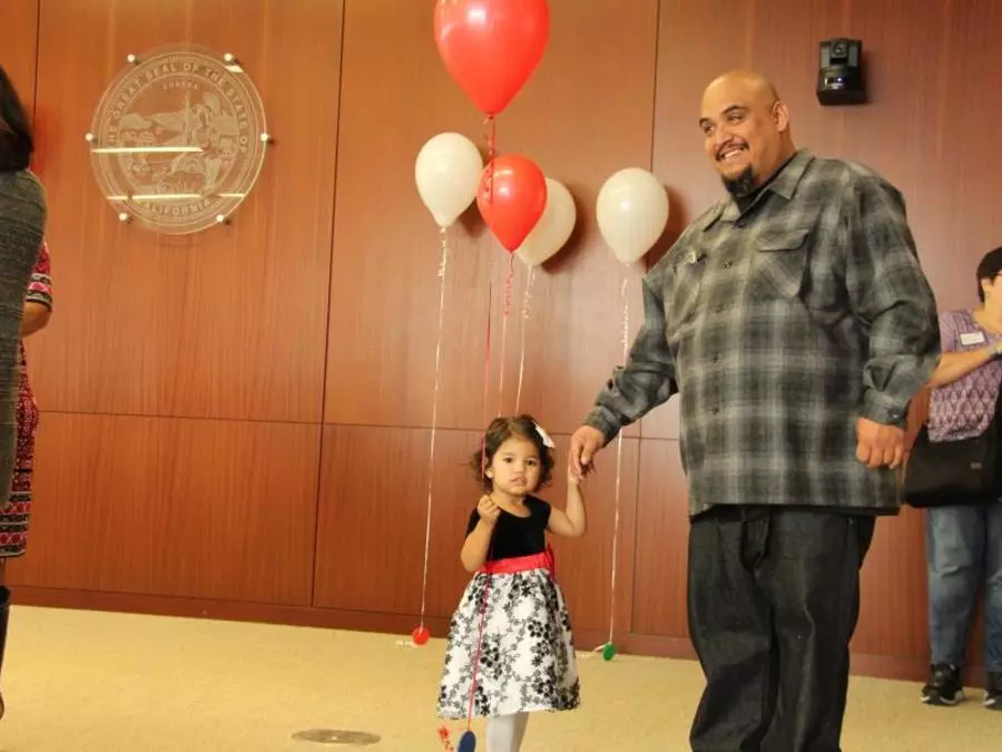 A father holds hands with his daughter at Adoption Day
